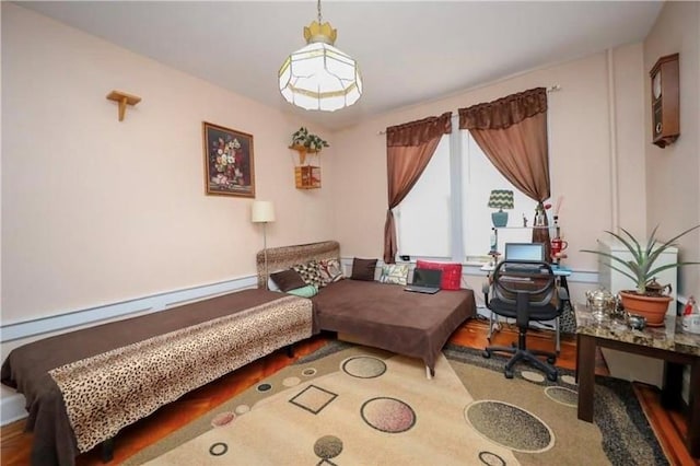 living area with wood-type flooring and a baseboard heating unit