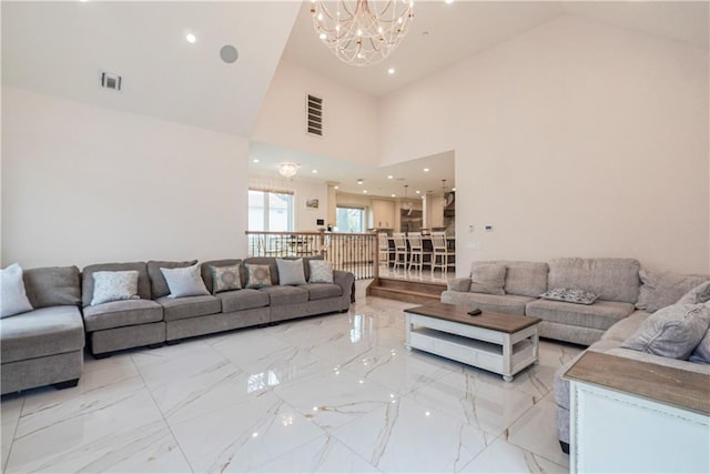 living room featuring a towering ceiling and a chandelier