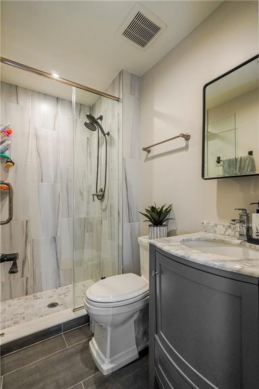 full bathroom with visible vents, a shower stall, toilet, and vanity