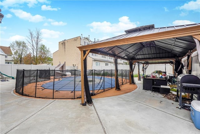 view of patio / terrace with a gazebo, a fenced in pool, and fence