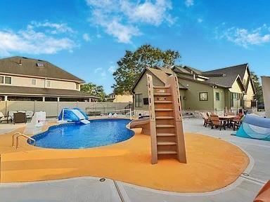 view of pool with a patio area and a water slide