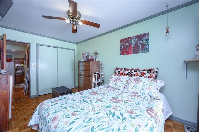 bedroom featuring parquet flooring, ceiling fan, crown molding, and a closet