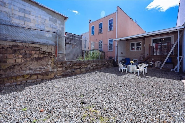 rear view of property featuring stucco siding and fence