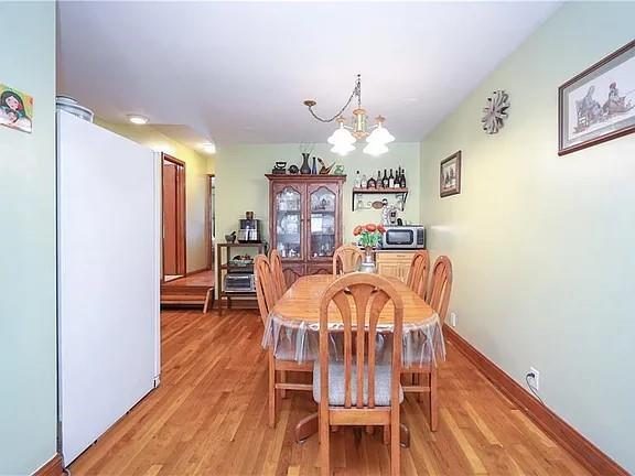 dining room with light wood-style floors and a chandelier