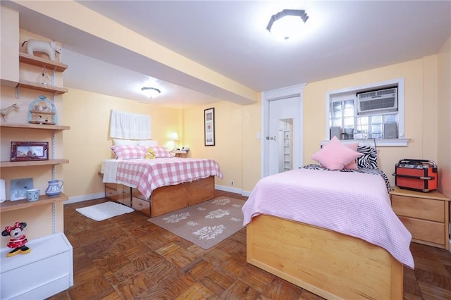 bedroom with a wall mounted AC and dark parquet floors