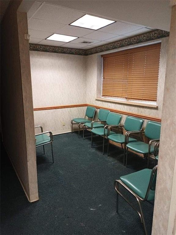 interior space with carpet floors and a paneled ceiling