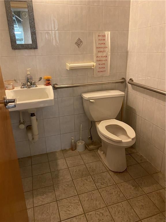 bathroom featuring tile patterned flooring, sink, toilet, and tile walls