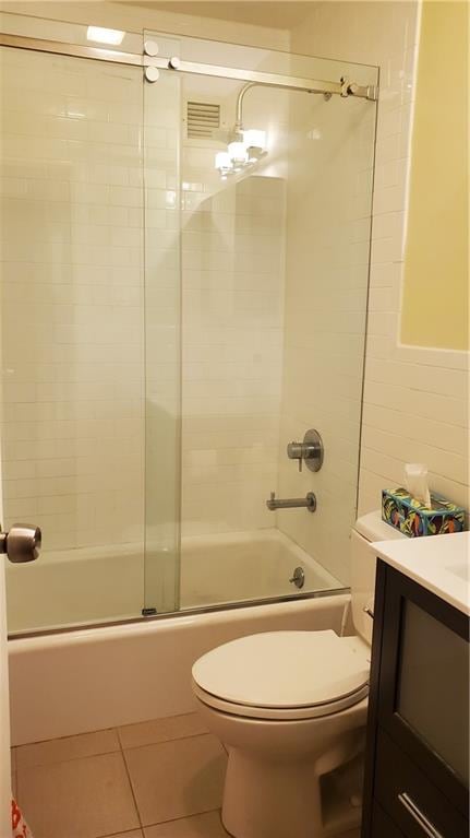 full bathroom featuring tile patterned flooring, vanity, toilet, and shower / bath combination with glass door