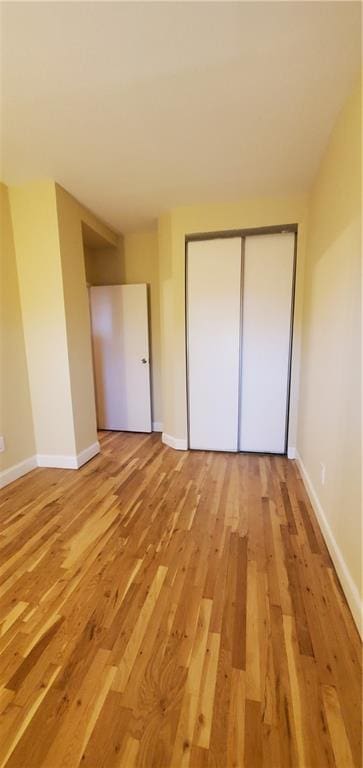 unfurnished bedroom featuring hardwood / wood-style flooring and a closet