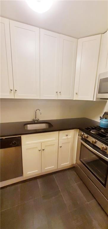 kitchen featuring high end range, white cabinets, dishwasher, and sink