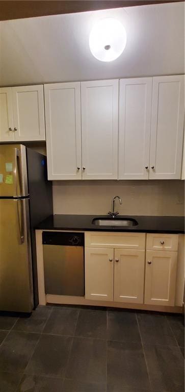 kitchen featuring white cabinetry, sink, dark tile patterned floors, and stainless steel appliances