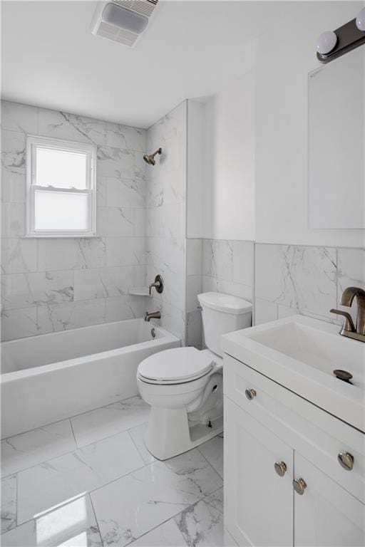 full bathroom featuring toilet, vanity, tile walls, and tiled shower / bath