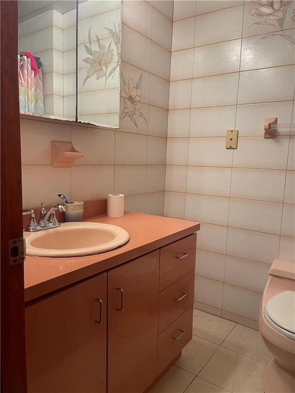 bathroom with tile walls, tile patterned flooring, vanity, and toilet