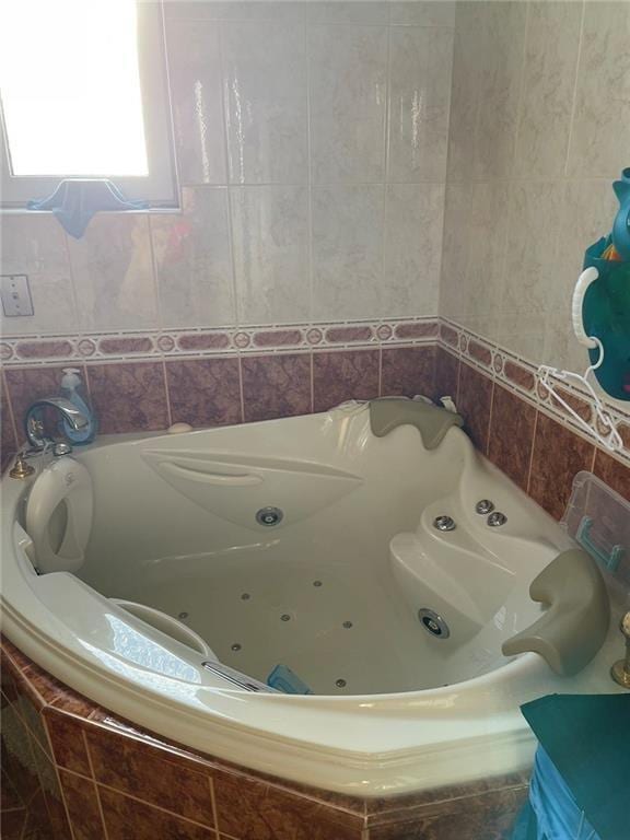 bathroom featuring tile walls and tiled tub