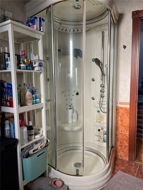 bathroom with tile patterned flooring and walk in shower