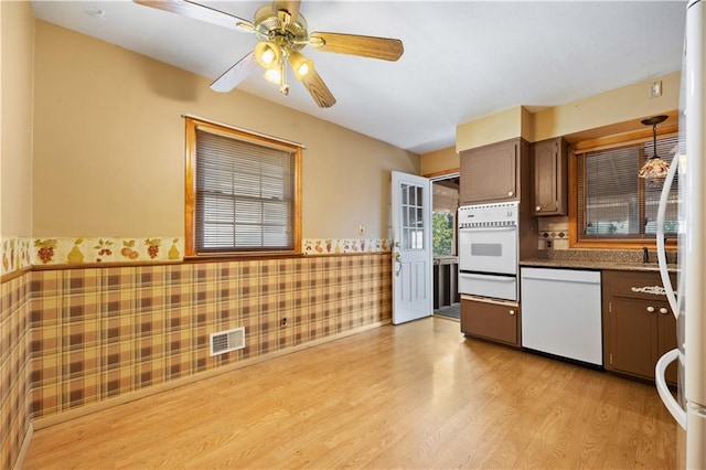 kitchen with dark brown cabinetry, ceiling fan, light hardwood / wood-style floors, and white appliances