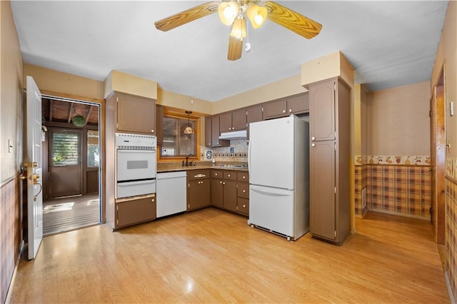 kitchen with white appliances, light hardwood / wood-style flooring, ceiling fan, and backsplash