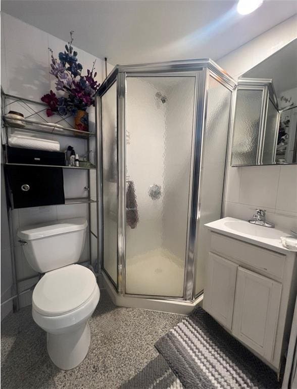 bathroom featuring walk in shower, vanity, and toilet