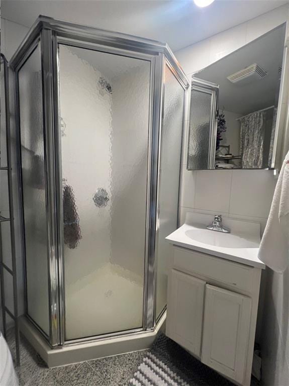 bathroom with vanity and a shower with door