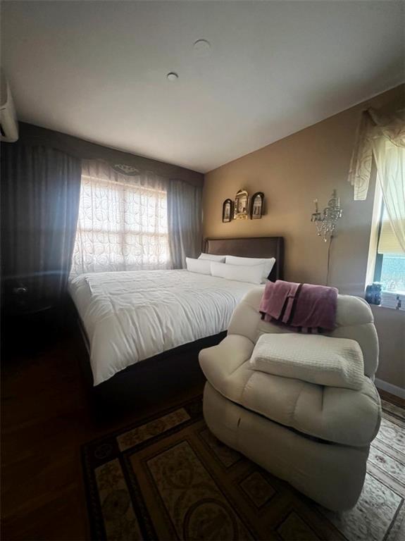 bedroom with multiple windows and hardwood / wood-style flooring