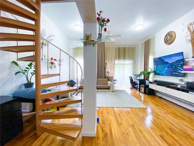 staircase featuring wood-type flooring and ceiling fan