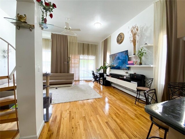 living room featuring hardwood / wood-style floors and ceiling fan