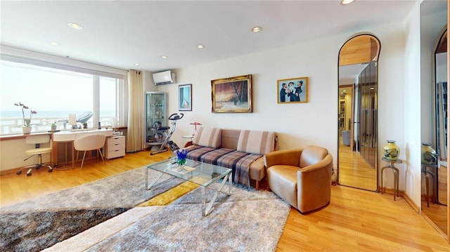 living room featuring a wall mounted AC and light wood-type flooring