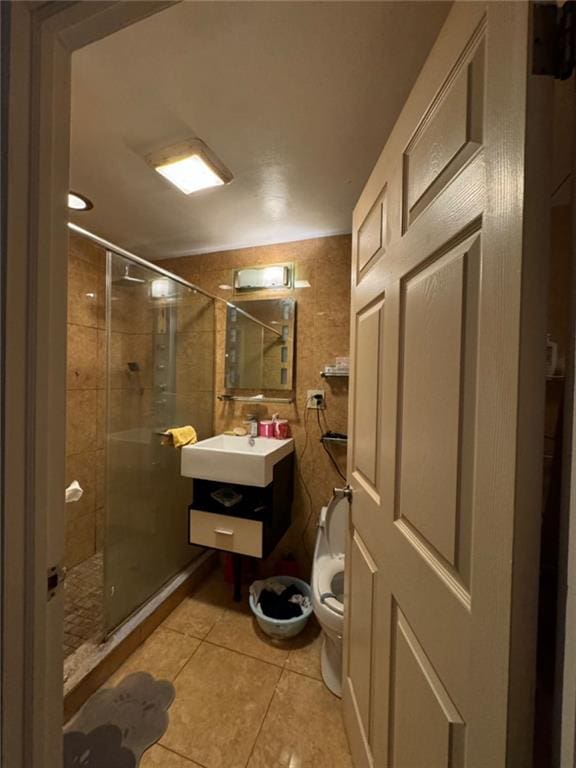 bathroom featuring tile patterned floors, vanity, toilet, and a shower with door