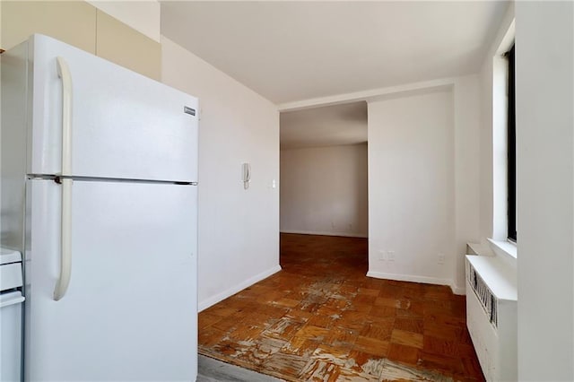 kitchen featuring light countertops, baseboards, and freestanding refrigerator