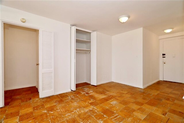 unfurnished bedroom with a closet and baseboards