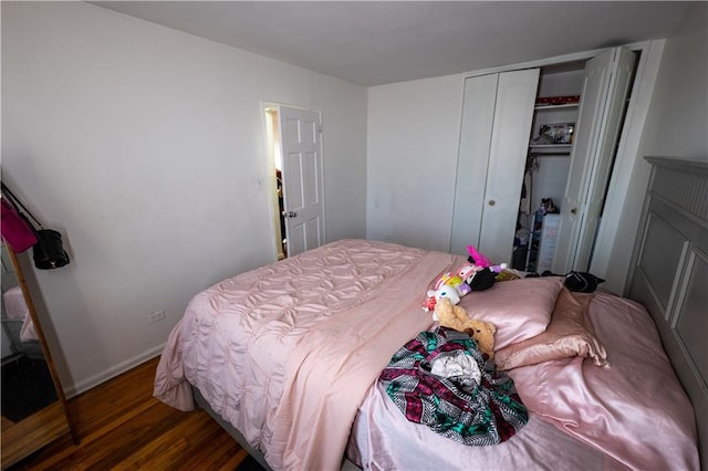 bedroom featuring wood finished floors, a closet, and baseboards