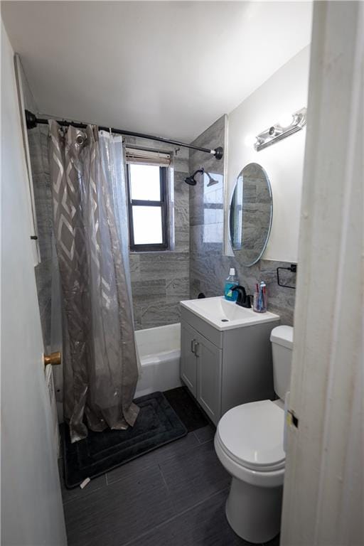 bathroom featuring toilet, tile walls, shower / tub combo with curtain, and vanity