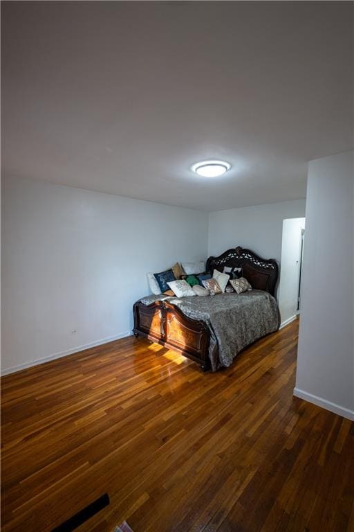 bedroom with baseboards and wood-type flooring