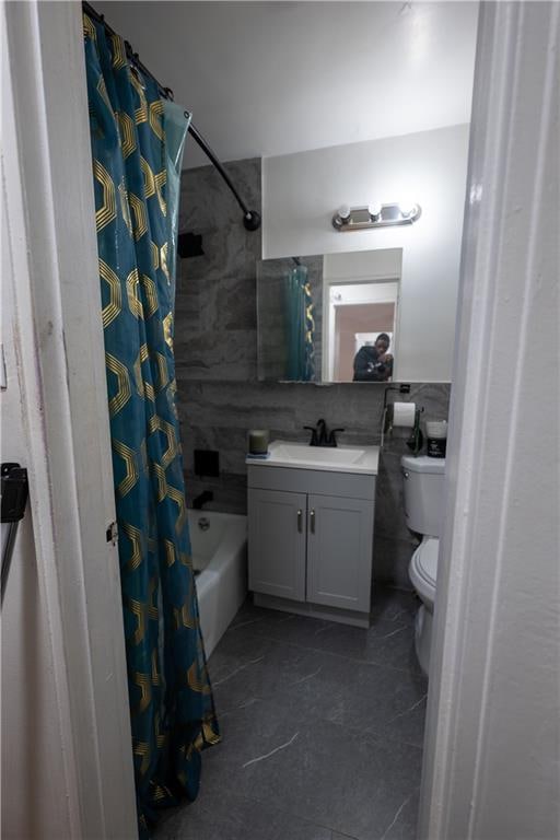 bathroom with tile walls, toilet, vanity, and shower / bathtub combination with curtain