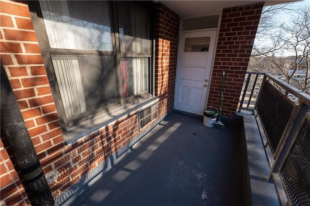 doorway to property with brick siding and a balcony