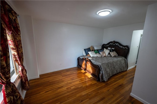 bedroom featuring baseboards and wood finished floors