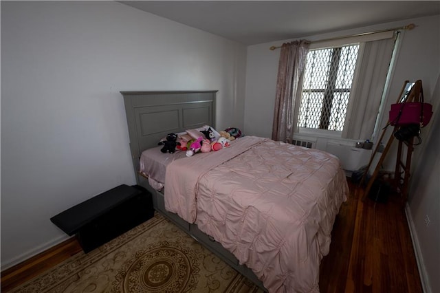 bedroom featuring baseboards and wood finished floors