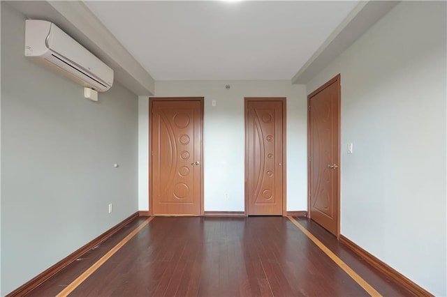 unfurnished bedroom with dark hardwood / wood-style flooring and an AC wall unit