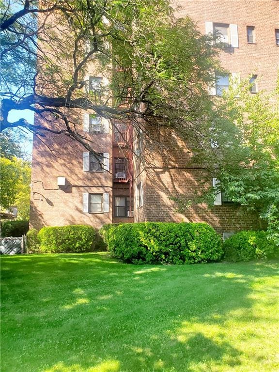 view of home's exterior with a lawn and brick siding