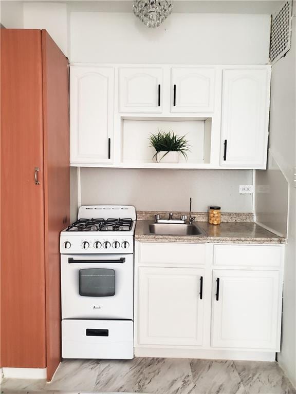 kitchen with white cabinetry, sink, and gas range gas stove