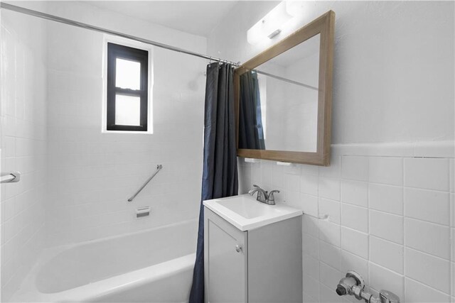 bathroom featuring vanity, shower / tub combo, and tile walls