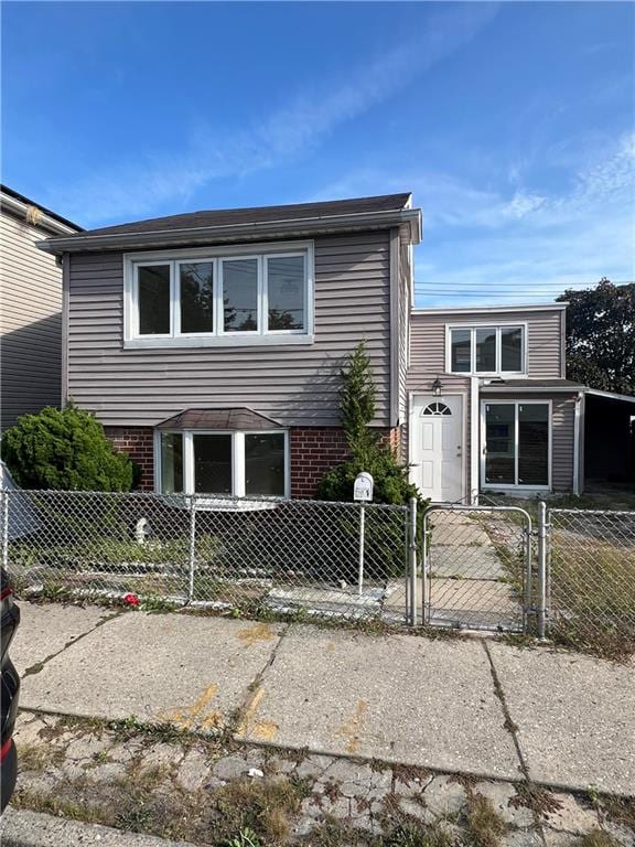 view of front of house featuring a fenced front yard, brick siding, and a gate