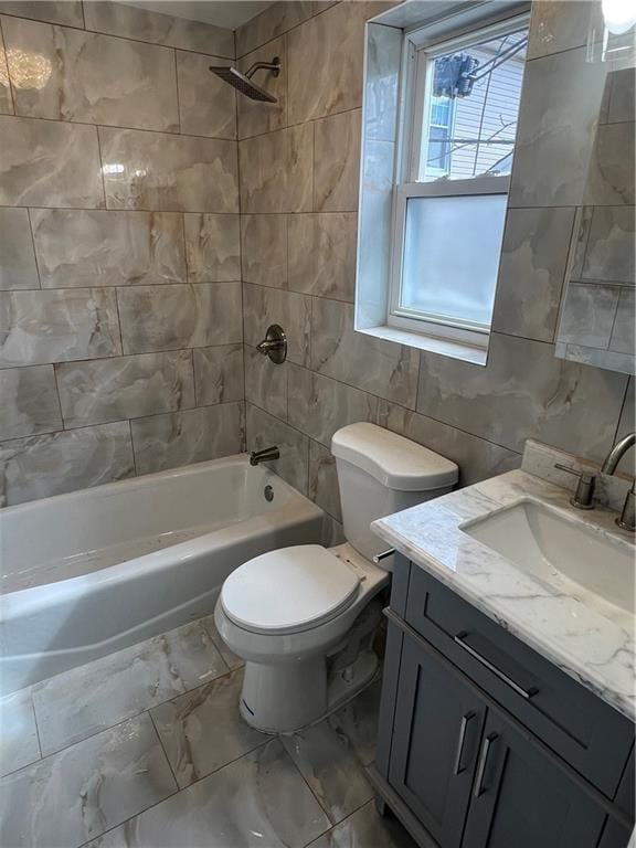 full bathroom with tile walls, tiled shower / bath combo, vanity, and toilet