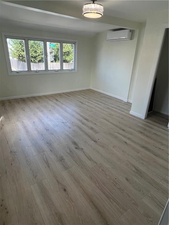 spare room with light hardwood / wood-style floors and a wall mounted air conditioner