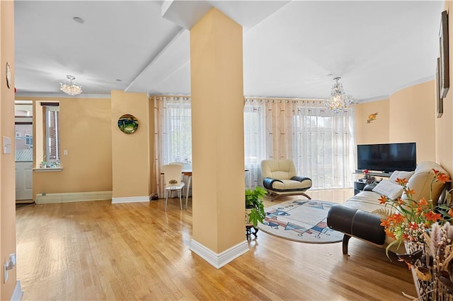 living room with a chandelier, wood-type flooring, and ornamental molding