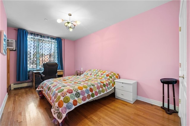 bedroom with a wall mounted AC, hardwood / wood-style floors, a baseboard radiator, and an inviting chandelier