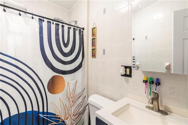 bathroom featuring vanity, toilet, curtained shower, and tile walls