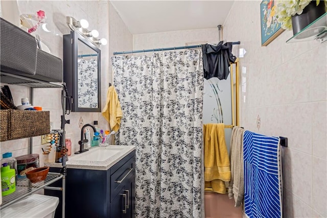 bathroom with vanity, tile walls, and a shower with shower curtain