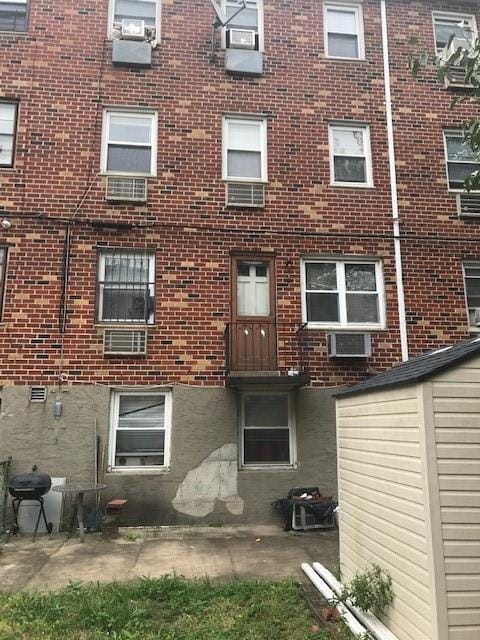 exterior space with a wall mounted air conditioner