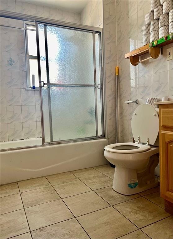 full bathroom featuring vanity, toilet, tile patterned floors, and shower / bath combination with glass door